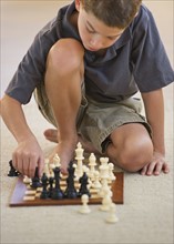 Boy (10-11) playing chess. Photo : Daniel Grill