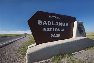 USA, South Dakota, Badlands National Park welcome sign on roadside.