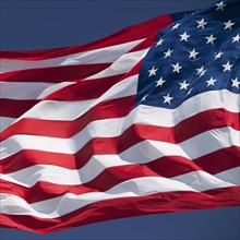 USA, South Dakota, American flag flapping against sky.