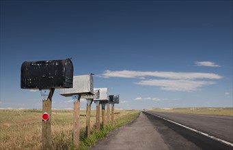 USA, South Dakota, Row of rural mailboxes on roadside.
