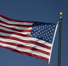 USA, South Dakota, American flag flapping against sky.