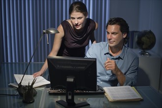 Man and woman working late in office.