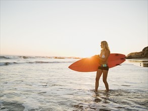 Portrait of woman with surfboard.
