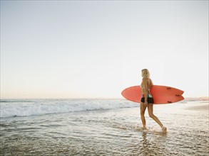 Portrait of woman with surfboard.