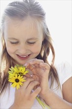 Girl (10-11) with sunflowers. Photo : Momentimages