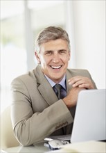 Portrait of businessman with laptop. Photo : Momentimages