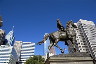 USA, Pennsylvania, Philadelphia, Statue depicting man on horse, skyscrapers in background. Photo :
