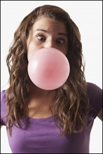 Young woman blowing bubble gum. Photo : Mike Kemp
