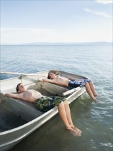 Boys (10-11,12-13) resting on boat.
