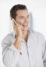 Portrait of good-looking mid adult man with mobile phone. Photo : Momentimages