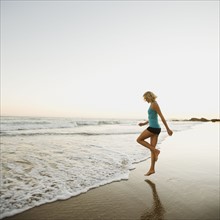 Portrait of woman running on beach.