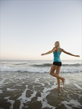 Portrait of woman running on beach.