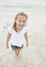 Portrait of smiling girl (10-11) at beach. Photo : Momentimages