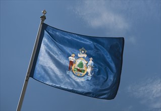 USA, Maine State flag against sky.