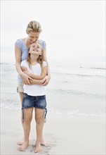 Mother with daughter (10-11) on beach. Photo : Momentimages
