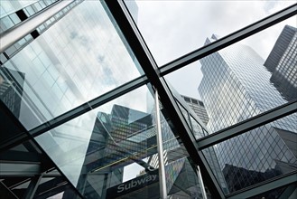 USA, New York State, New York City, Tall skyscrapers seen through glass ceiling of modern office