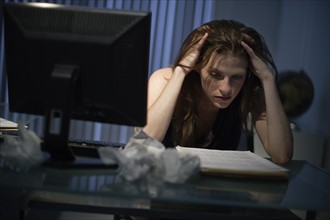 Exhausted woman working late in office.