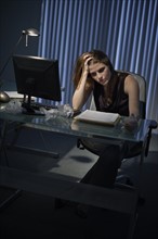 Exhausted woman working late in office.