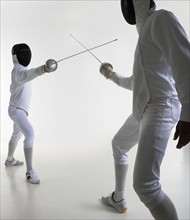Studio portrait of fighting fencers.