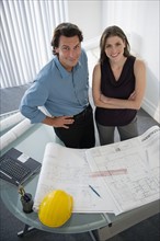 Architects with blueprints in office.