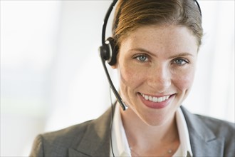 Portrait of smiling woman with headset.