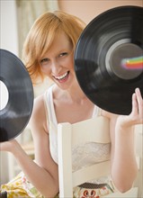 Portrait of young woman holding vinyl records. Photo : Jamie Grill