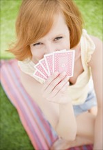 Young woman holding cards. Photo : Jamie Grill