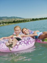 Girls (6-7,8-9) floating on inflatable toys.