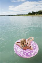 Girl (6-7) floating on inflatable ring.