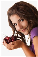 Young woman holding cherries. Photo : Mike Kemp