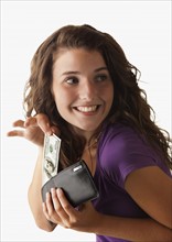 Young woman removing banknote from wallet. Photo : Mike Kemp