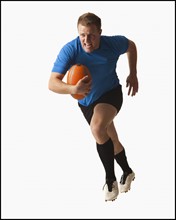 Male rugby player running with ball. Photo : Mike Kemp