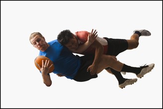 Rugby players tackling for ball. Photo : Mike Kemp