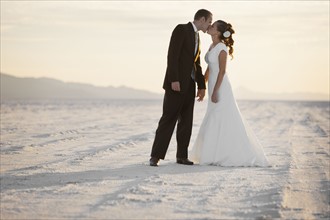 Groom kissing bride in desert. Photo : FBP