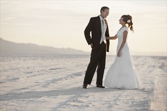 Bride and groom standing in desert. Photo : FBP