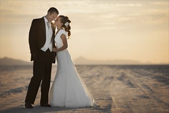 Bride and groom embracing in desert. Photo : FBP