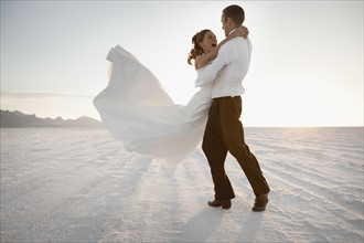 Bride and groom embracing in desert. Photo : FBP