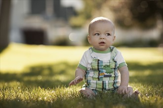 Baby boy (6-11 months) sitting on grass. Photo : FBP