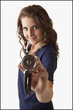 Portrait of young nurse holding stethoscope. Photo : Mike Kemp
