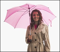 Studio portrait of young woman with umbrella. Photo : Mike Kemp