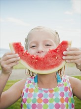 Girl (6-7) eating watermelon.