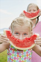 Girls (6-7,8-9) eating watermelon.