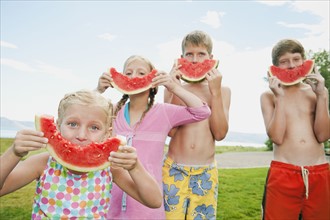 Kids (6-7,8-9,10-11,12-13) eating watermelon.