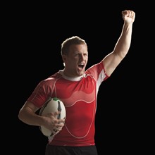 Male rugby player holding ball, celebrating. Photo : Mike Kemp
