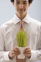 Studio portrait of young man holding wheat grass. Photo : FBP