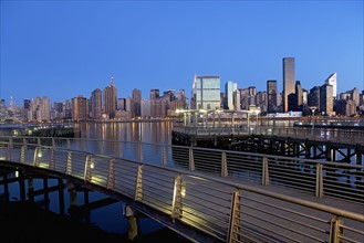 USA, New York State, New York City, Boardwalk in waterfront, Manhattan skyline in background. Photo