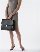 Young woman with briefcase, studio shot.