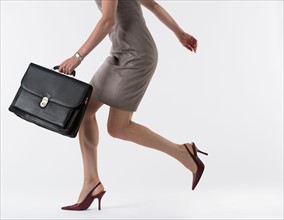 Young woman with briefcase, studio shot.