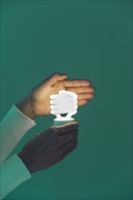 Woman's hands holding energy efficient lightbulb.