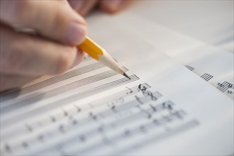 Man writing notes on sheet music.
